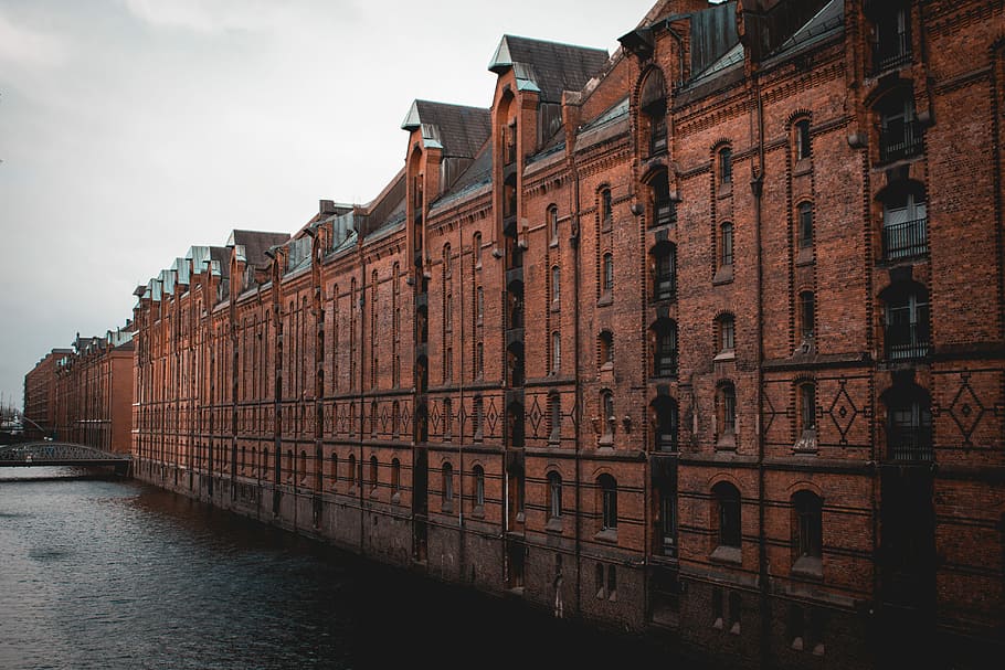 photo of brown building beside body of water, brown and black concrete building near body of water HD wallpaper