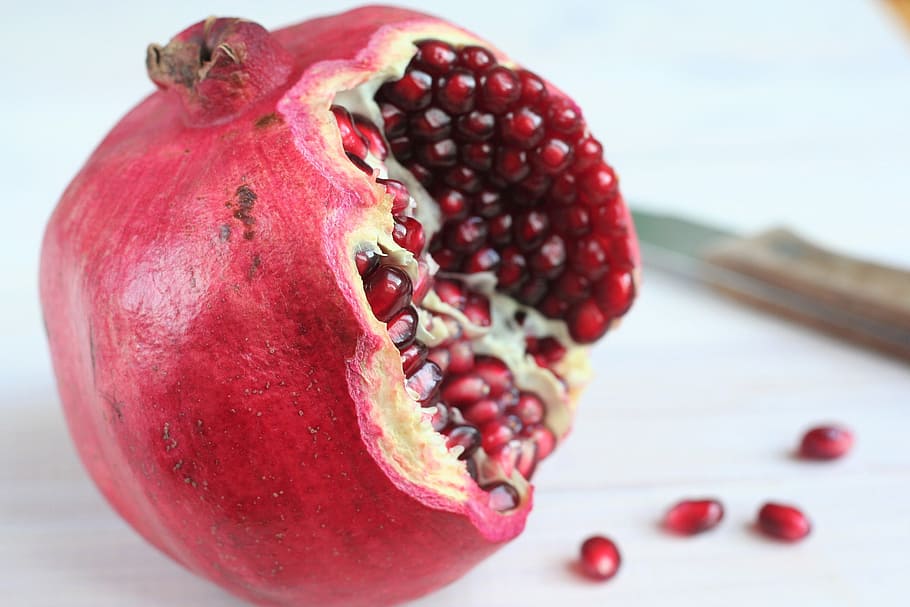 red pomegranate on white surface, Antioxidant, Vitamins, ripe fruit, HD wallpaper