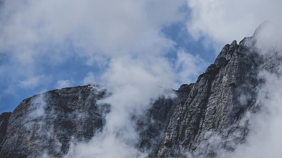 mountain covered with clouds, clouds surrounding gray rocky mountain HD wallpaper