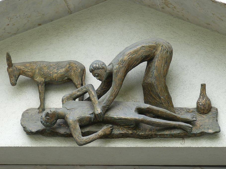 person lifting unconscious person on ground beside donkey figurine HD wallpaper