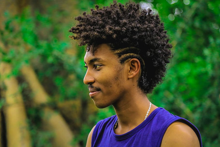 selective focus photography of man wearing purple sleeveless top, man standing near green plant HD wallpaper