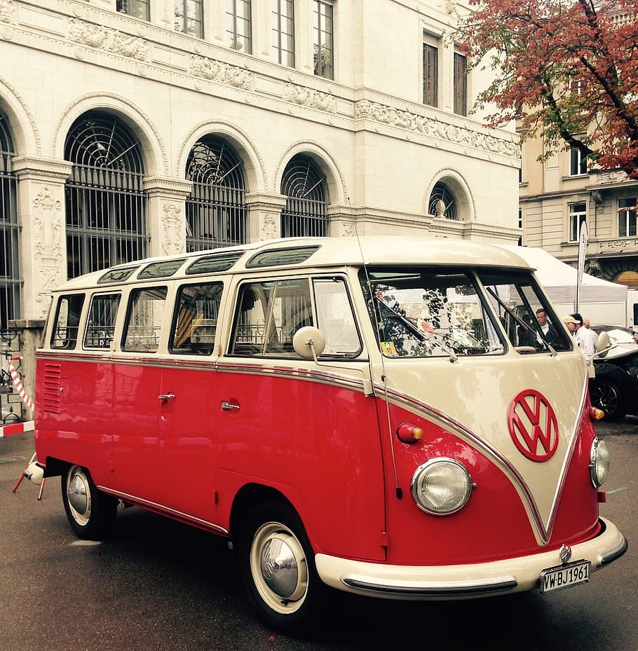 red and white Volkswagen T2 van on road near concrete building during daytime
