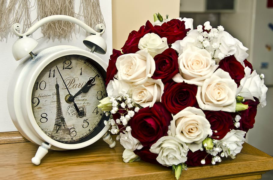 round white Paris analog alarm clock and bouquet of red and white flowers on brown wooden table HD wallpaper