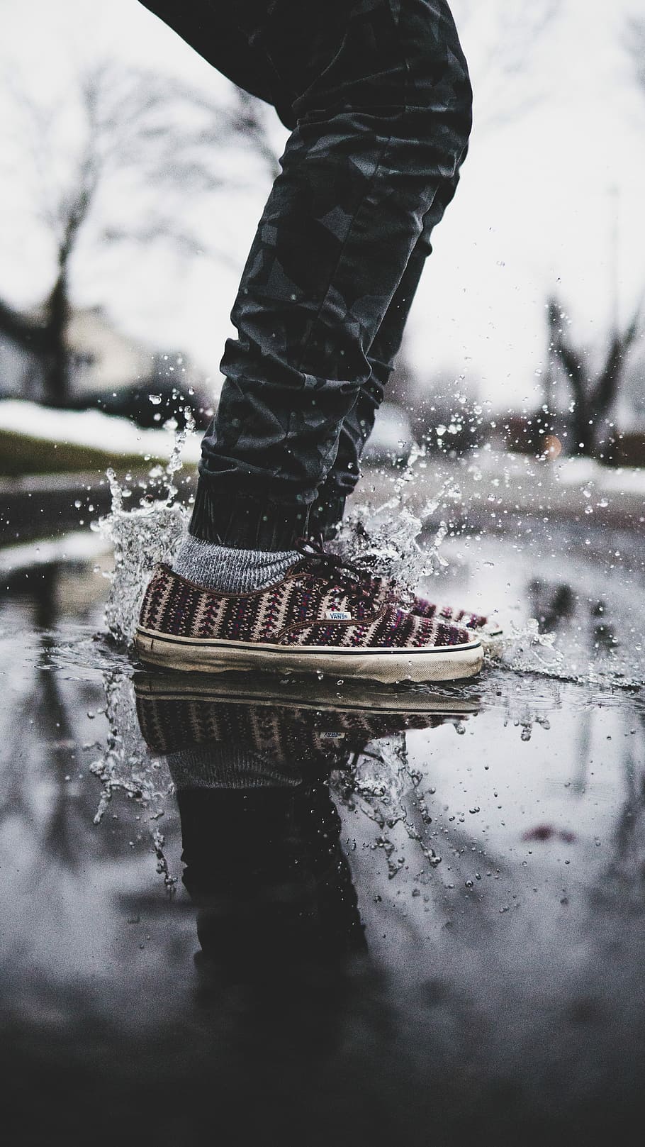 person wearing black pants and black-and-white low-top sneakers on wet floor, person splashing the water under white cloudy sky photo, HD wallpaper