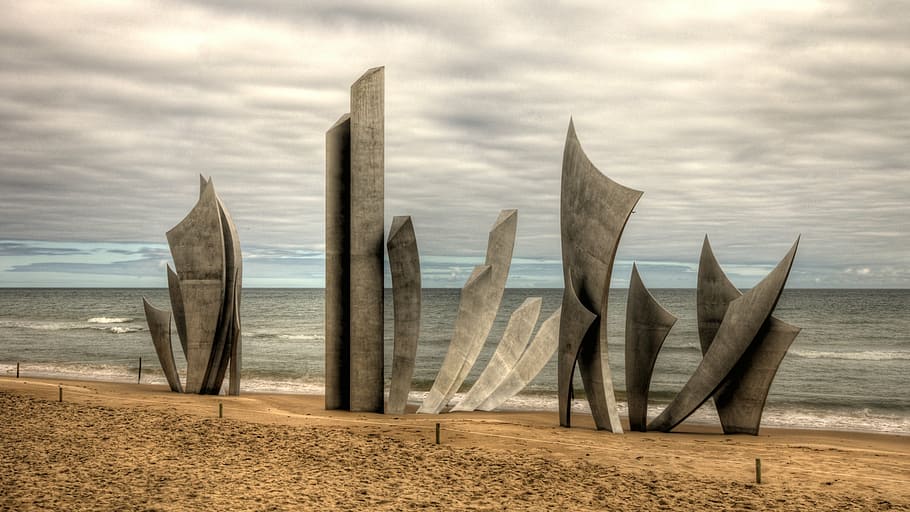 gray abstract figure on the seashore, omaha beach, monument des braves