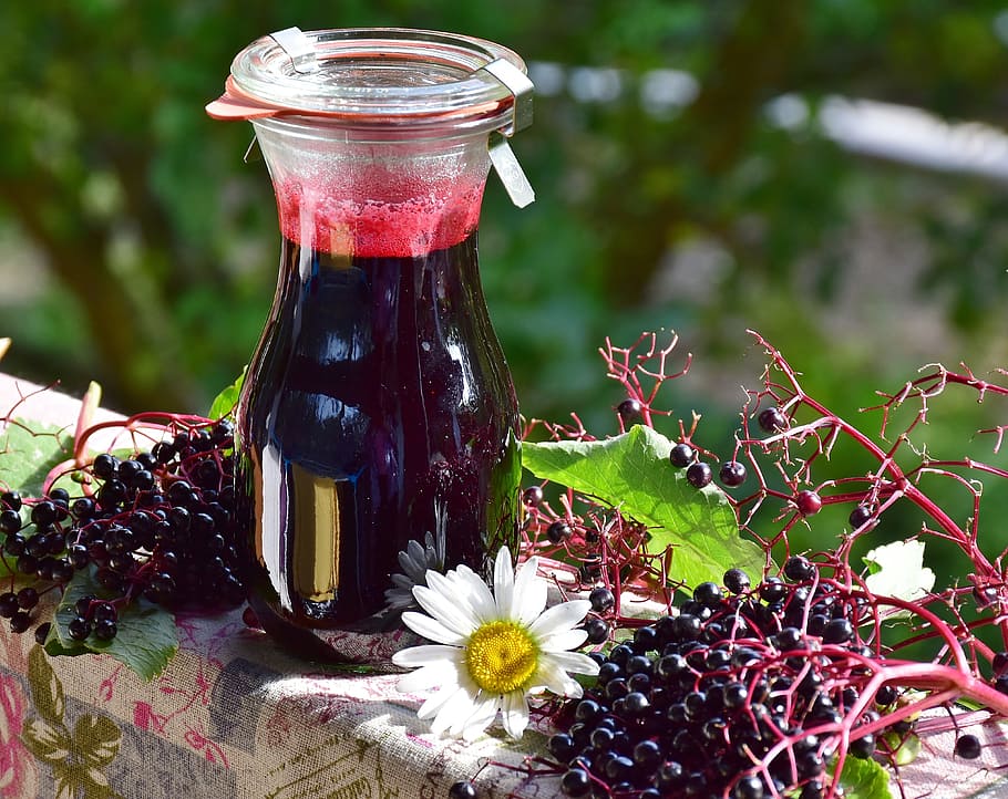 selective focus photography of clear glass bottle filled with berry juice HD wallpaper