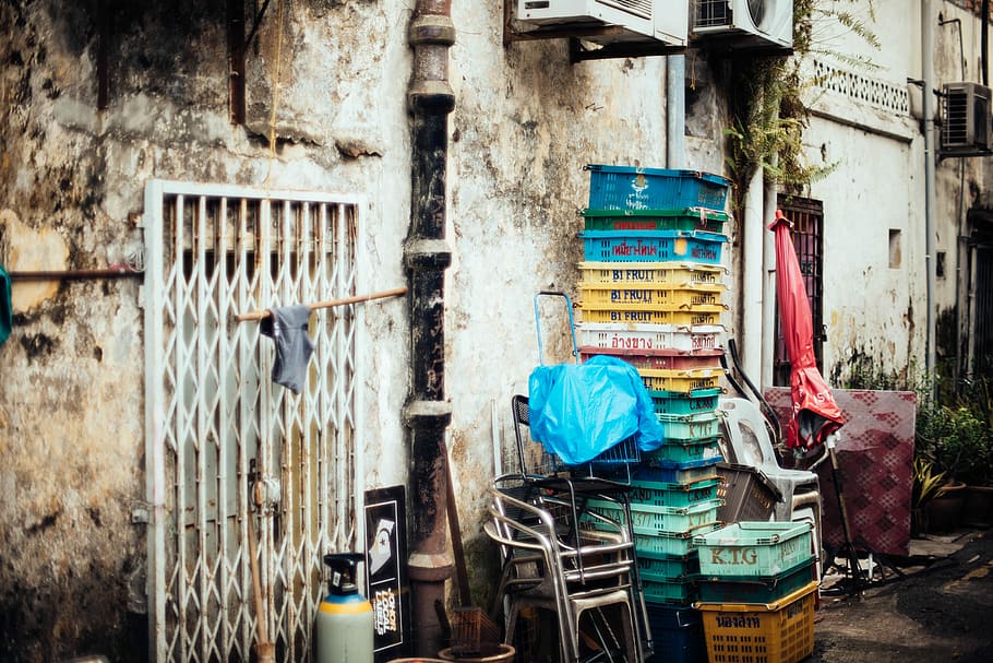 laundry basket stacked beside wall, assorted-color plastic crates beside gray building HD wallpaper
