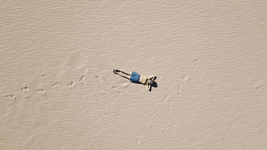 aerial photograph of man lying on sand, person lying on open white sand in aerial photography at daytime HD wallpaper