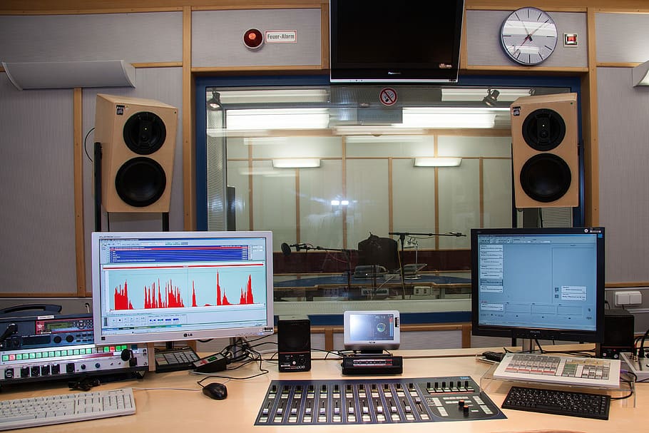 black audio mixer with two computer monitors, sound studio, speaker cab