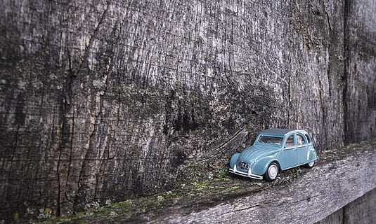 blue Volkswagen beetle die-cast model on gray wooden board HD wallpaper