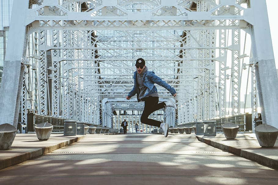 man jumping on grey and white bridge during daytime, man doing jump shot in bridge HD wallpaper