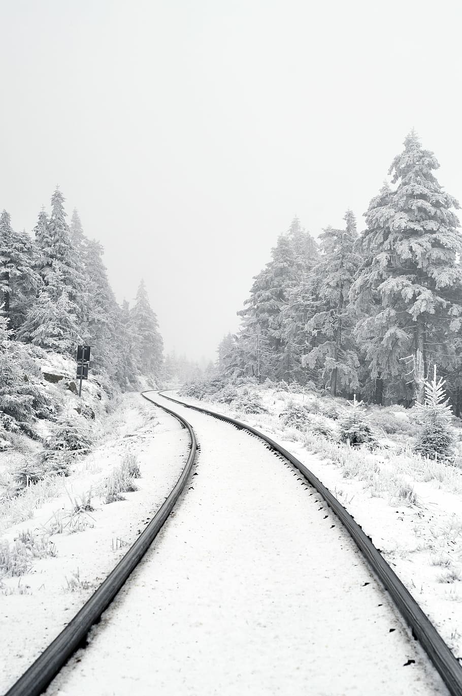 railway covered by snow, grayscale photography of snow covered train rail way