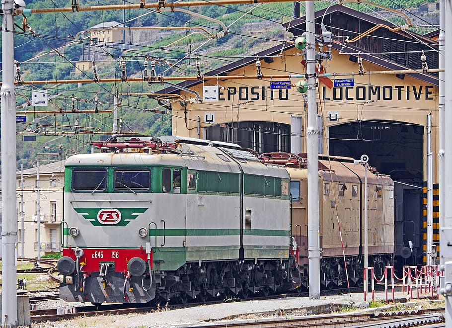 green and gray train in train trail at daytime, electric locomotives