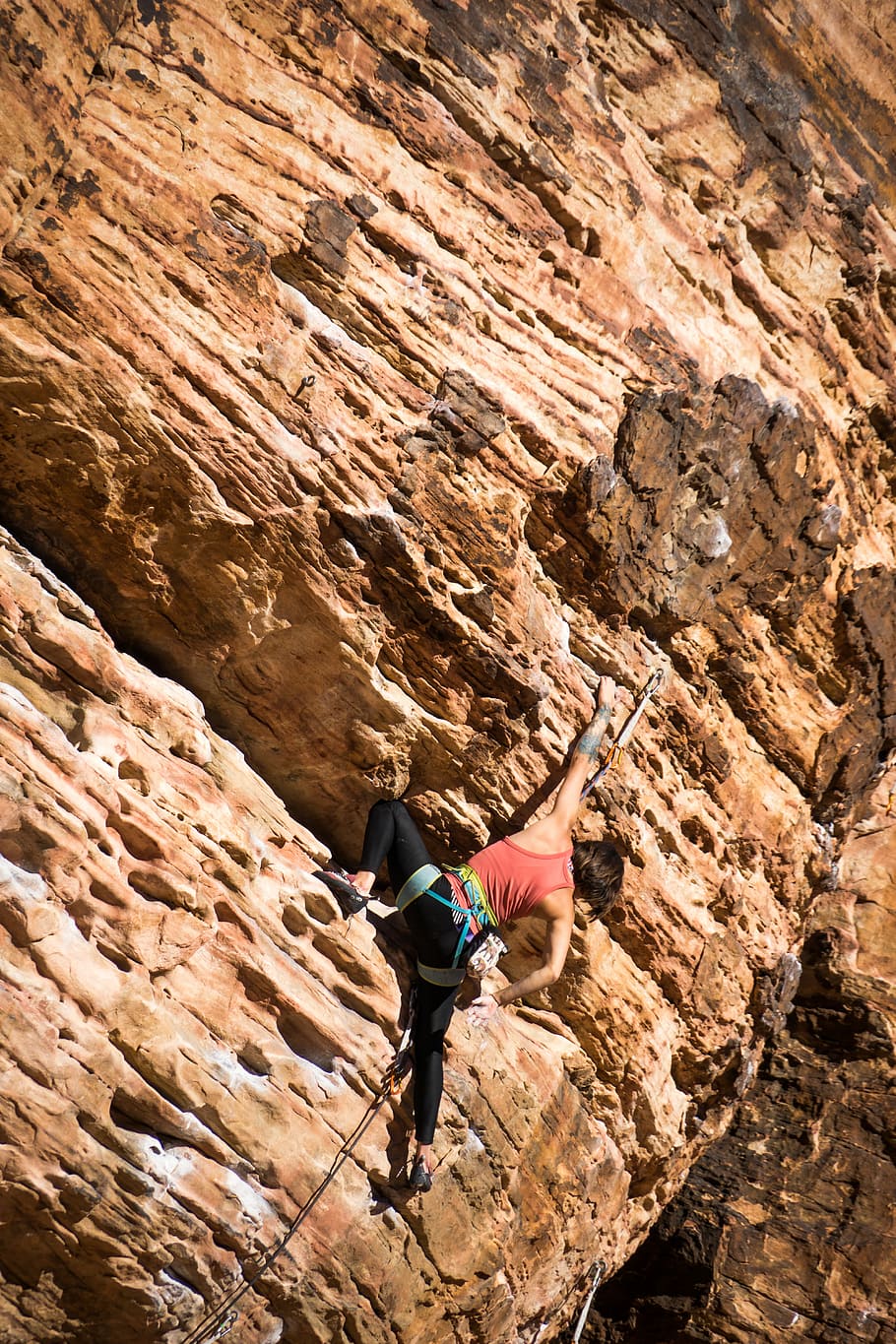 woman climbing rocky mountain, person climbing cliff, female