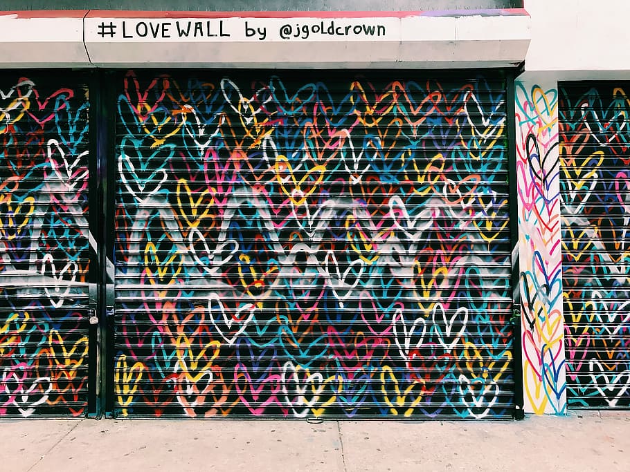 photo of black door shutter filled with heart murals, assorted-color heart graffiti wall arts