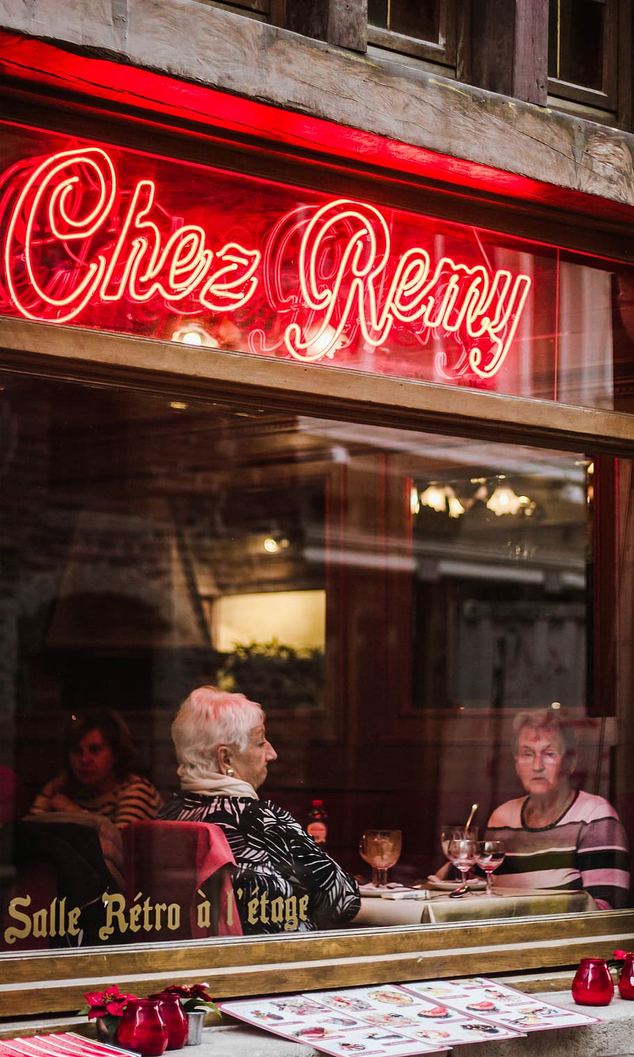 turned on Chez Remy neon signage during daytime, two women sitting inside of restaurant HD wallpaper
