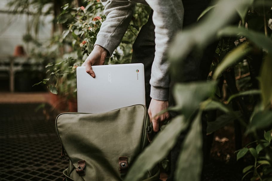 Sponsored by Google Chromebooks, person holding Acer Chromebook laptop on an opened gray bag inside building with flowers, HD wallpaper