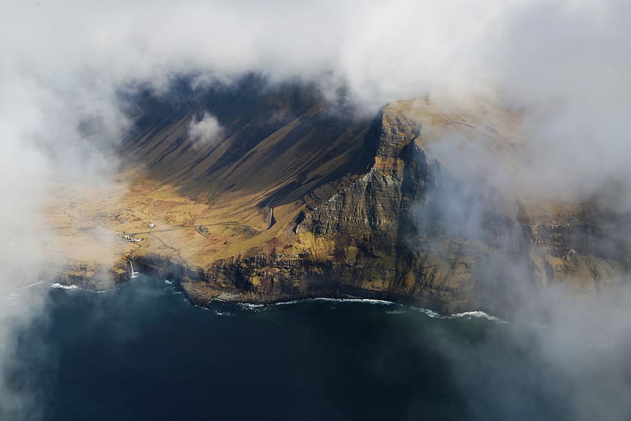 bird's eye view photography of cliff and mountain, aerial photo of mountain near ocean HD wallpaper