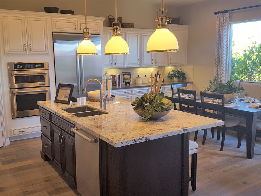 grey kitchen island with three beige pendant lamps turned on HD wallpaper