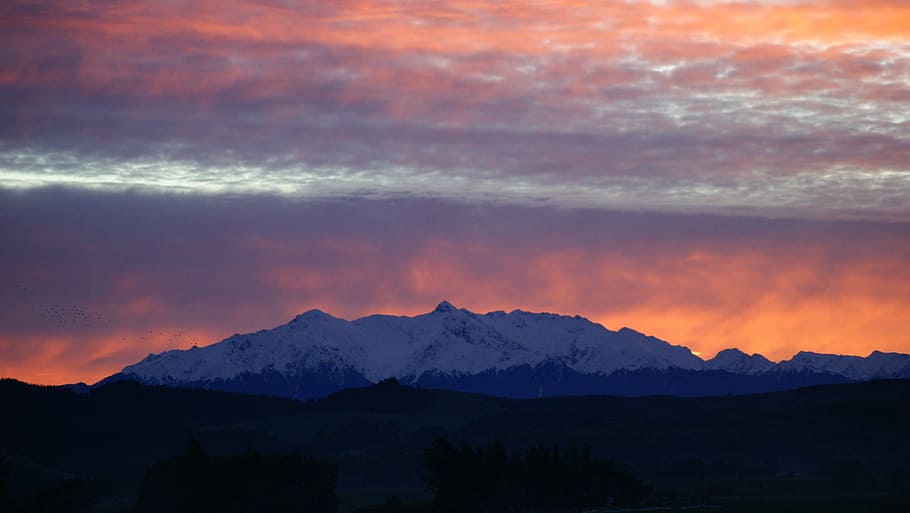 sunset over snow-cover mountain range, photo of snow coated mountain HD wallpaper