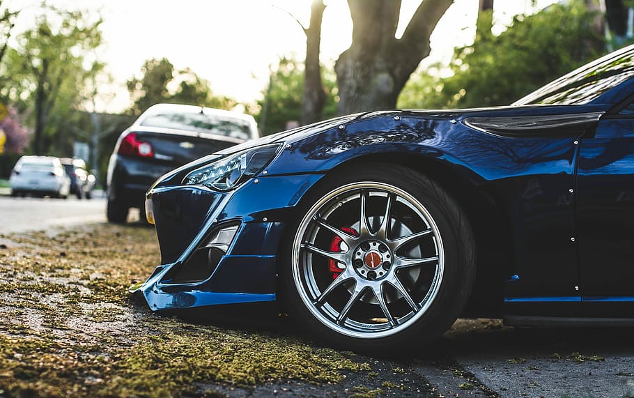 blue vehicle beside tree trunk, closeup photography of blue car parked near tree during daytime HD wallpaper