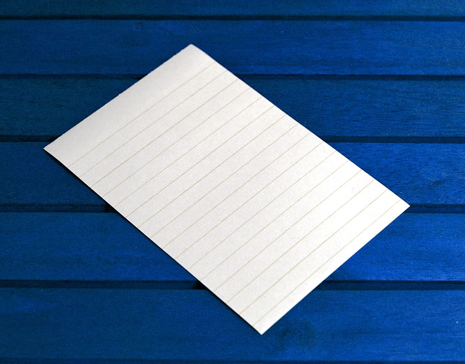 empty white lined paper on blue surface, post it, notes, message