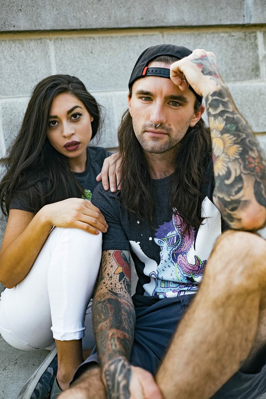 man and woman sitting near wall while taking selfie, couple HD wallpaper