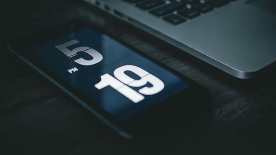 black smartphone beside laptop, opened space gray iPhone 6 at 5pm and 19 near silver MacBook HD wallpaper