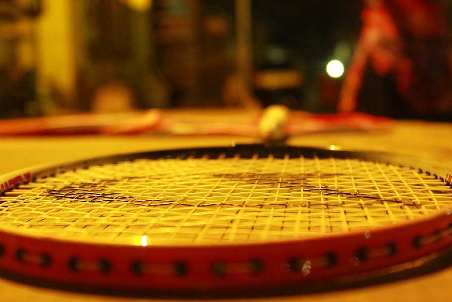 selective focus photo of black and red badminton racket, sport