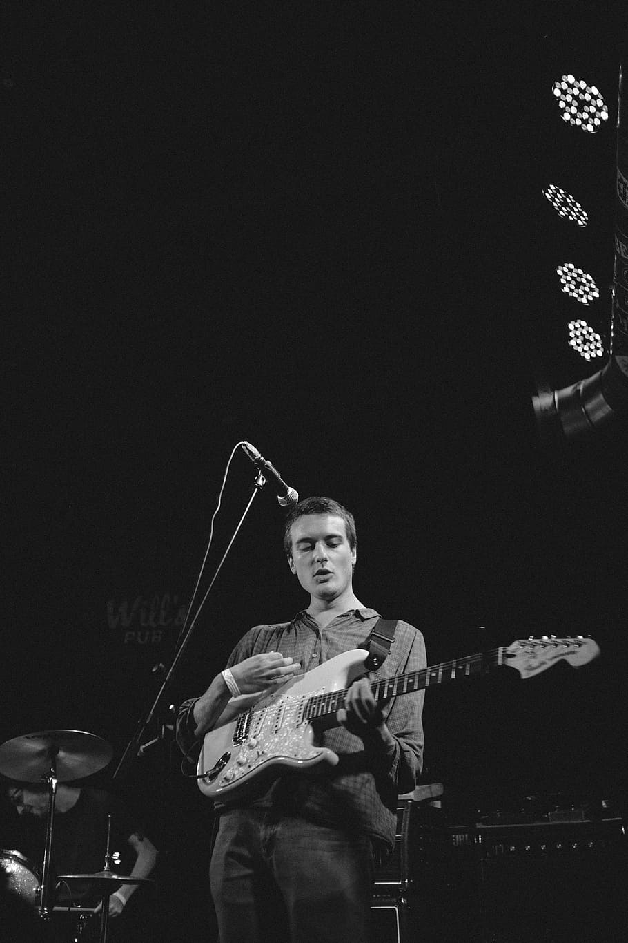grayscale photography of man playing guitar on stage, grayscale photography of man playing electric guitar