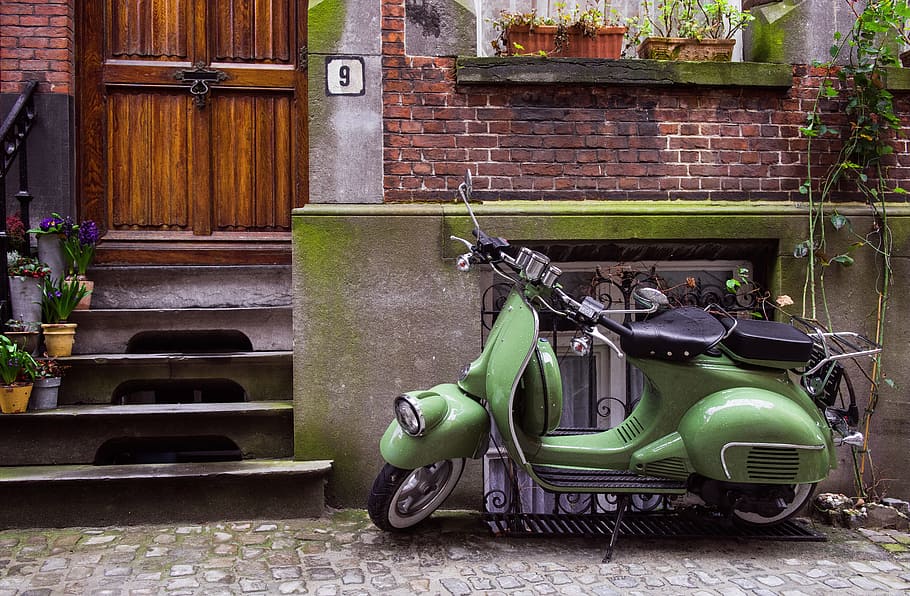 green motor scooter parked on roadside, moped, building, bike