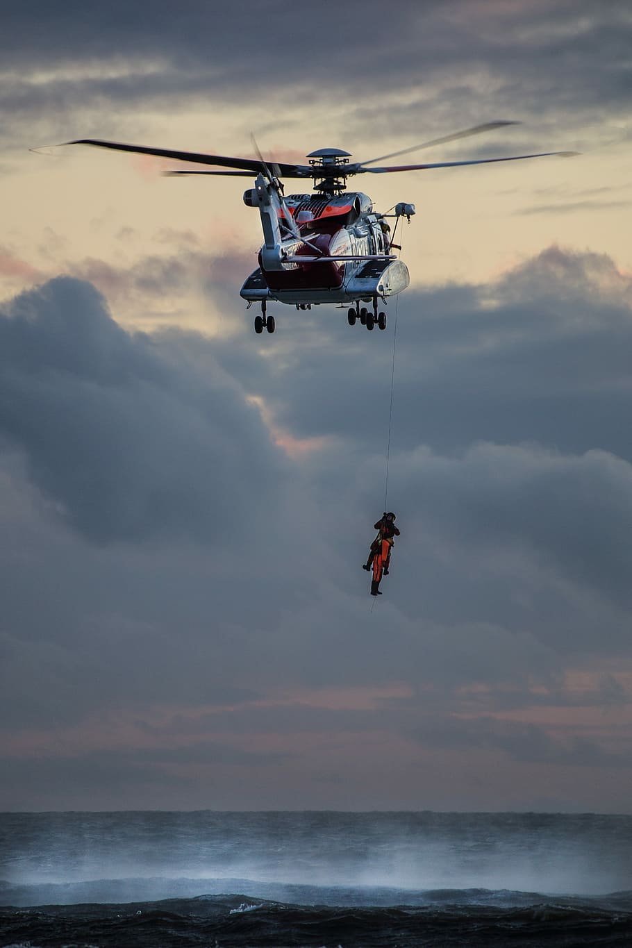 A rescue from a helicopter in Dinas Dinlle from the water, photo of person hanging on rescue helicopter during daytime, HD wallpaper