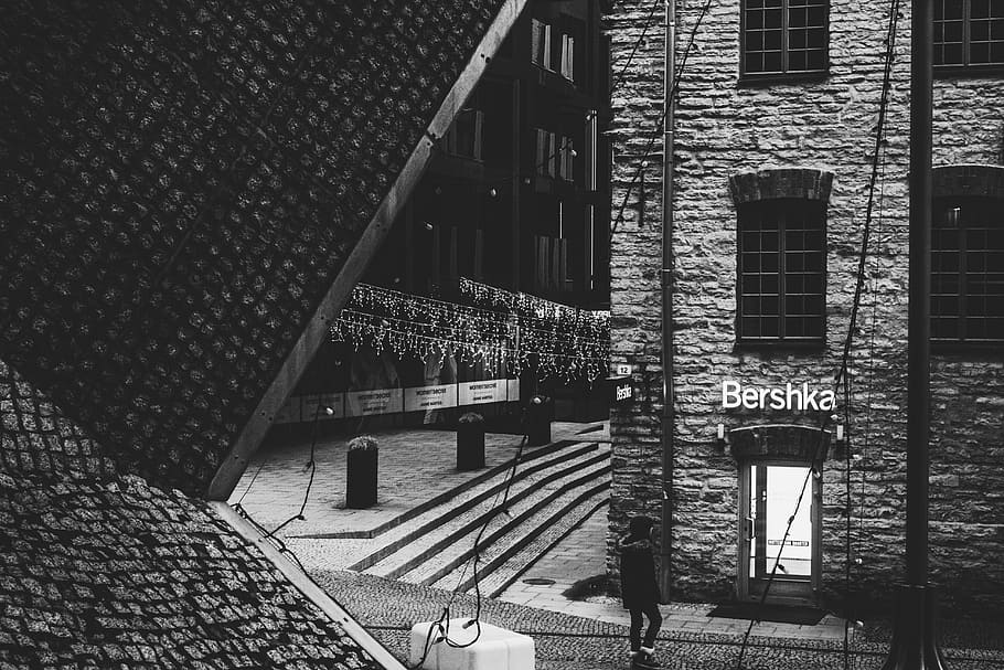 Person Standing Near Bershka Building Grayscale Photography, architecture