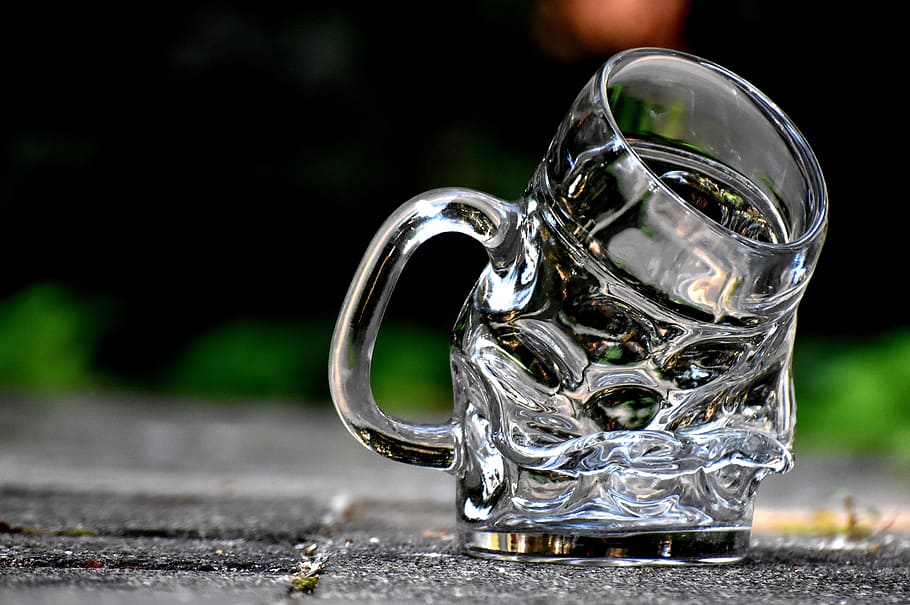 selective focus of melting glass mug, deformed, bent, beer glass
