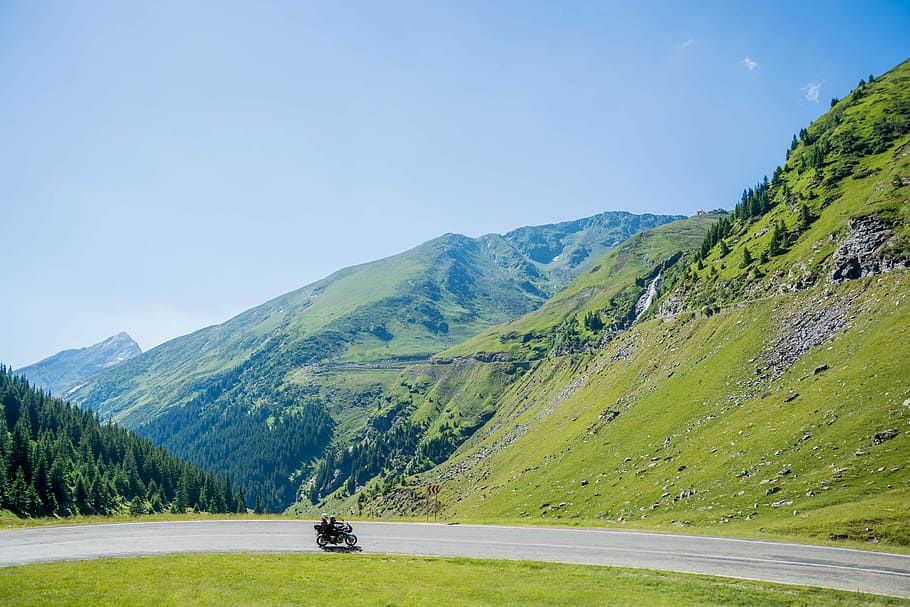 gray concrete roadway under blue sky, motorcycle in the middle of road HD wallpaper