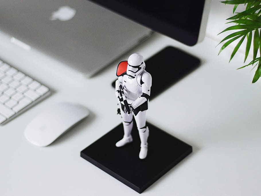 Star Wars Stormtropper figurine on table, plastic Storm Trooper figure beside Magic Mouse