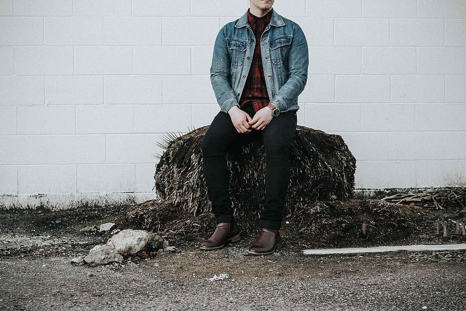 man wearing blue denim western shirt sitting next to white concrete wall, man wearing denim jacket sitting on rock HD wallpaper