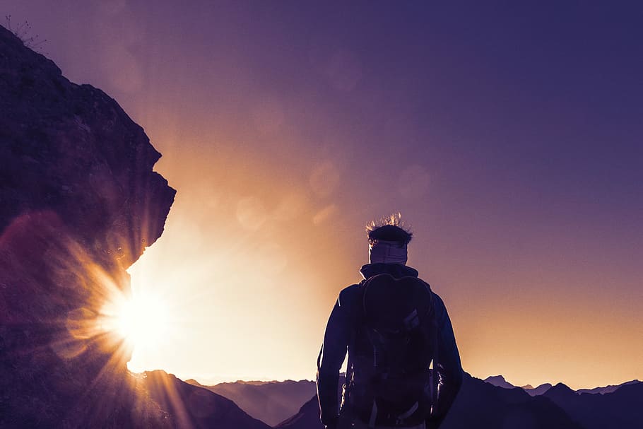 silhouette photography of standing person near boulder, person with backpack standing near rock HD wallpaper