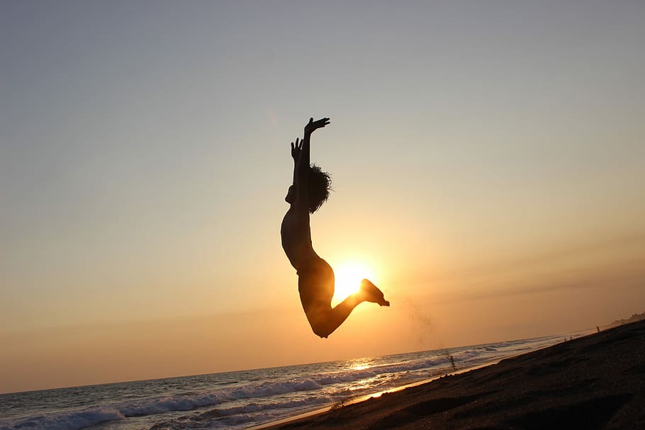 silhouette of child jumping on seashore, sunset, sky, dawn HD wallpaper