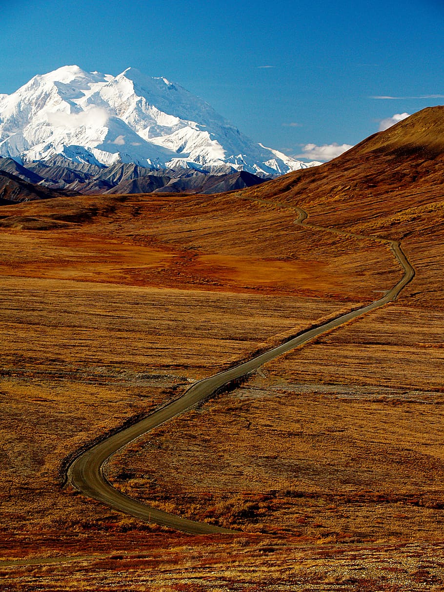 plains near mountain under blue sky, aerial photo of road on open field HD wallpaper