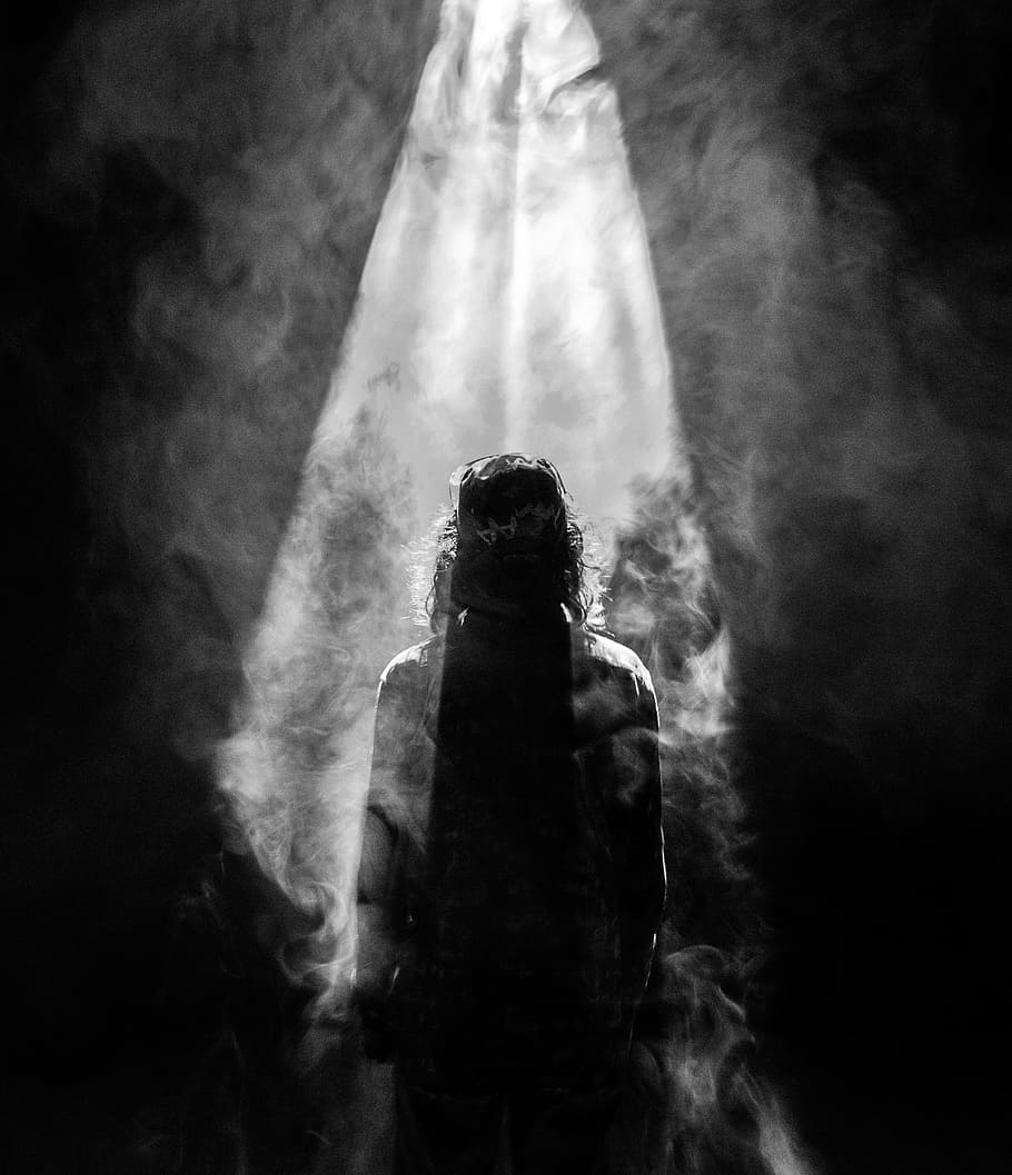 photograph of person facing opposite in smoky spotlight, untitled
