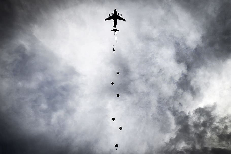 silhouette of airplane under cloudy sky, parachute, training