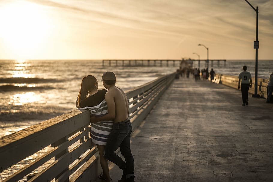 man cuddling woman beside rail, couple, relationship, pier HD wallpaper