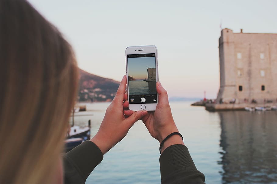 woman showing photo of building near body of water, dubrovnik