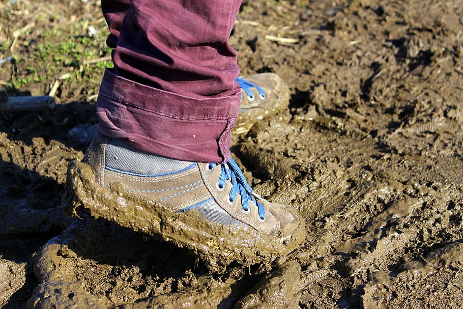 person wearing blue-and-brown shoes, earth, wet earth, mud, ground
