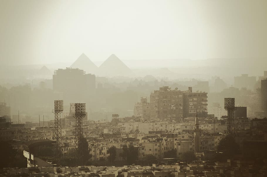aerial photo of gray buildings near pyramids, city covered with fog during daytime, HD wallpaper