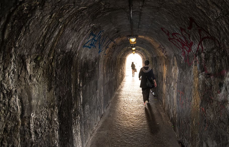 woman walking inside gray concrete tunnel, alley, girl, shadow