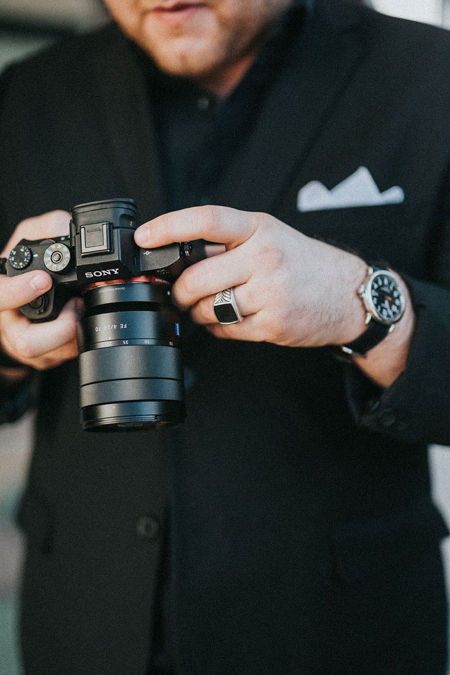 man holding black Sony DSLR camera, person using black Sony DSLR camera HD wallpaper