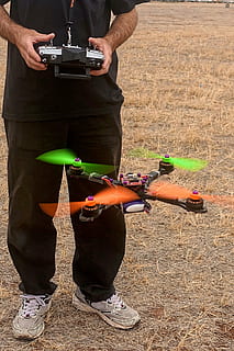 person controlling black quadcopter drone, remote control, multi rotor HD wallpaper