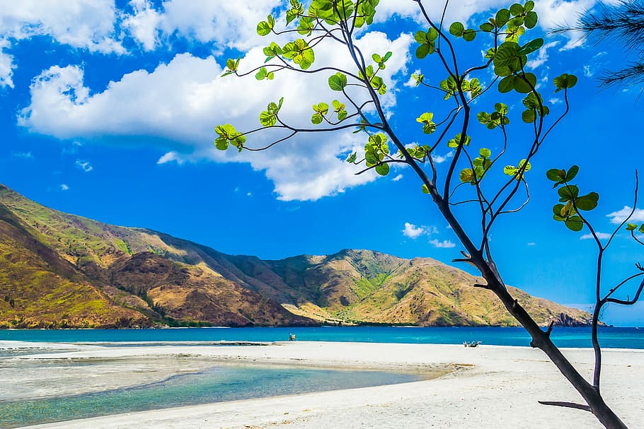 blue ocean water with mountain under blue sky and white clouds view during daytime HD wallpaper
